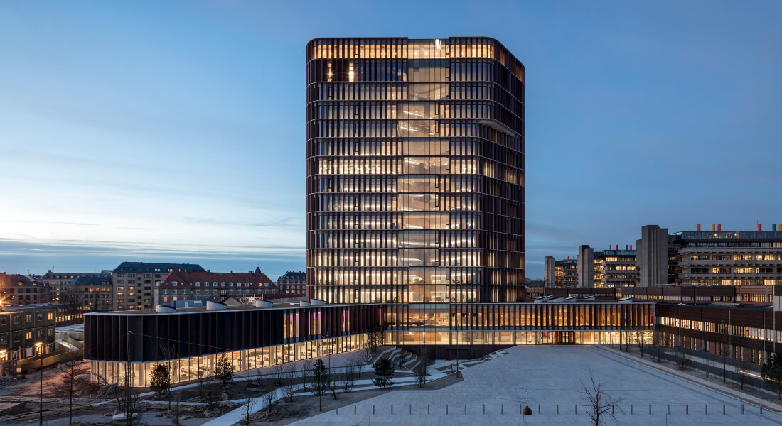 Mærsk-tårnet i tusmørke med oplyste vinduer.